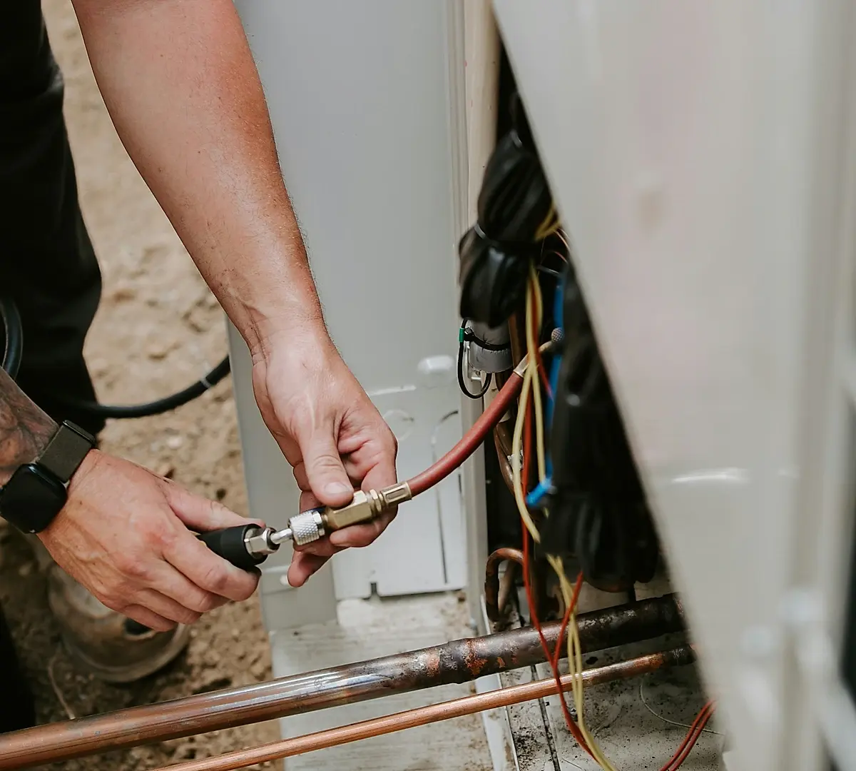 Technician connecting gauges to new copper refrigerant lines